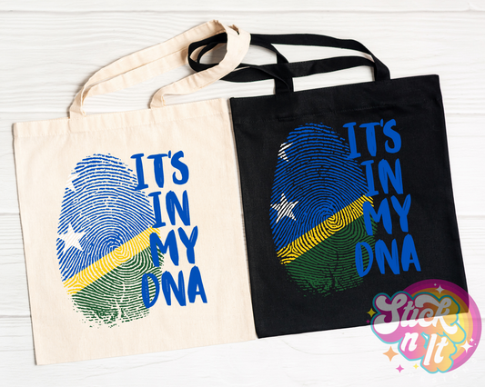 Black and natural coloured tote bags featuring quote It's in my DNA with fingerprint shaped Solomon Islands flag.