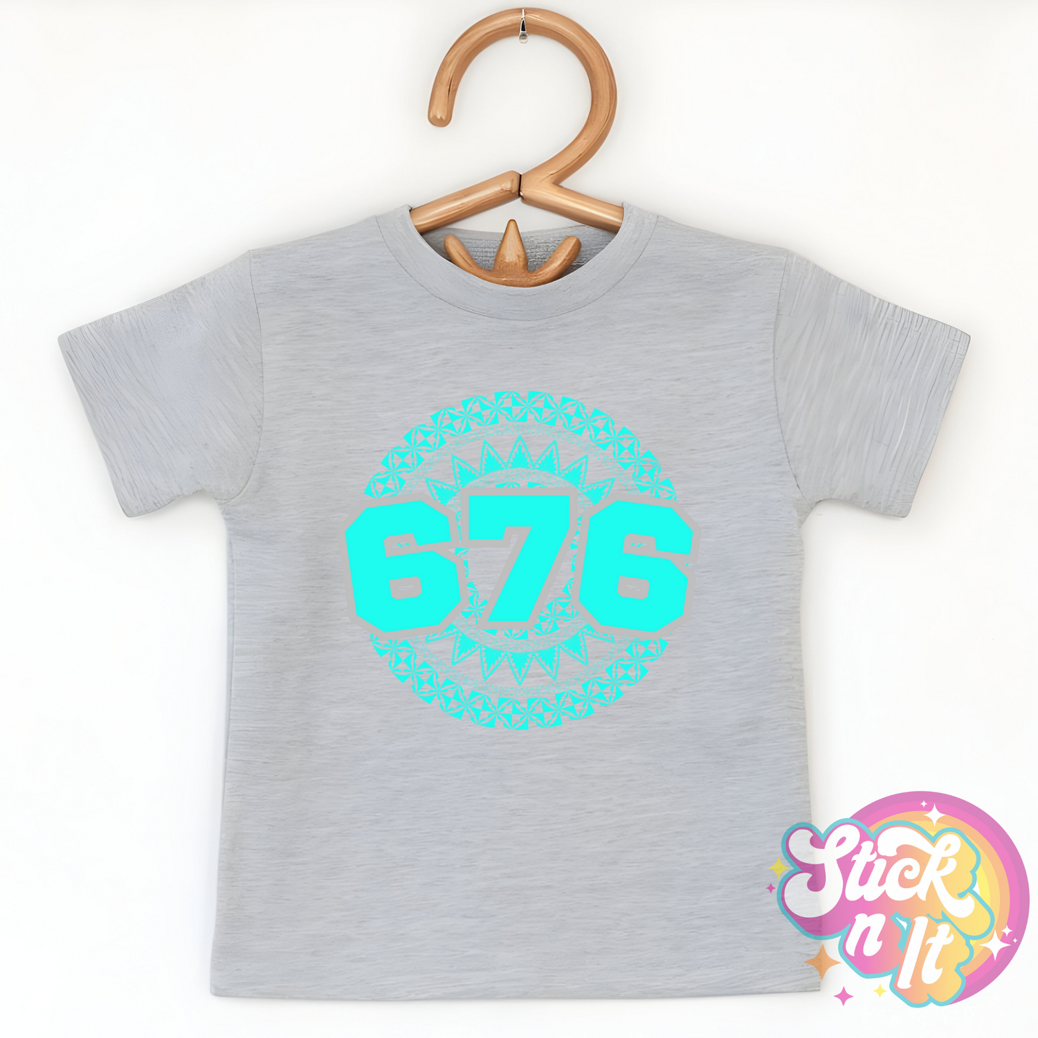 Kids size grey shirt featuring a Polynesian Tonga design with area code 676 in aqua.
