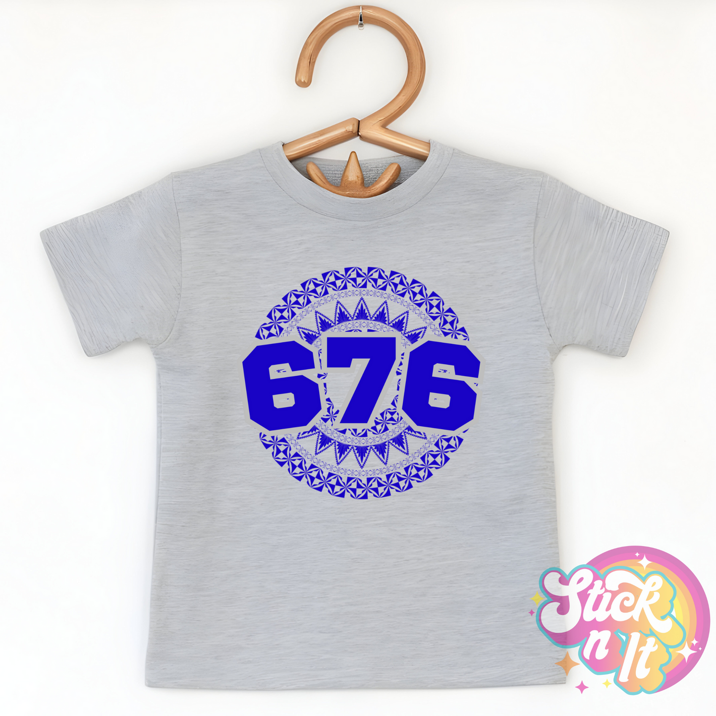 Kids size grey shirt featuring a Polynesian Tonga design with area code 676 in blue.