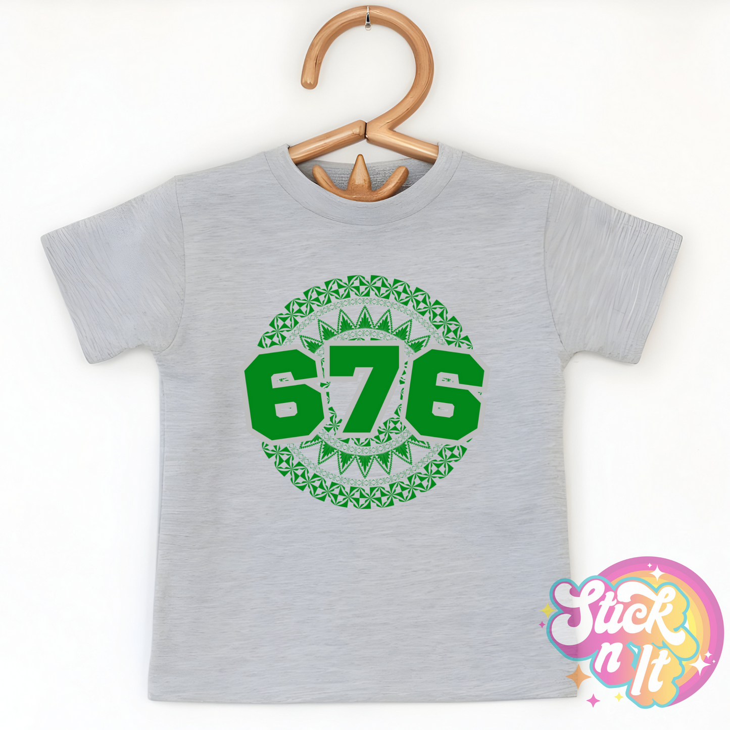 Kids size grey shirt featuring a Polynesian Tonga design with area code 676 in green.