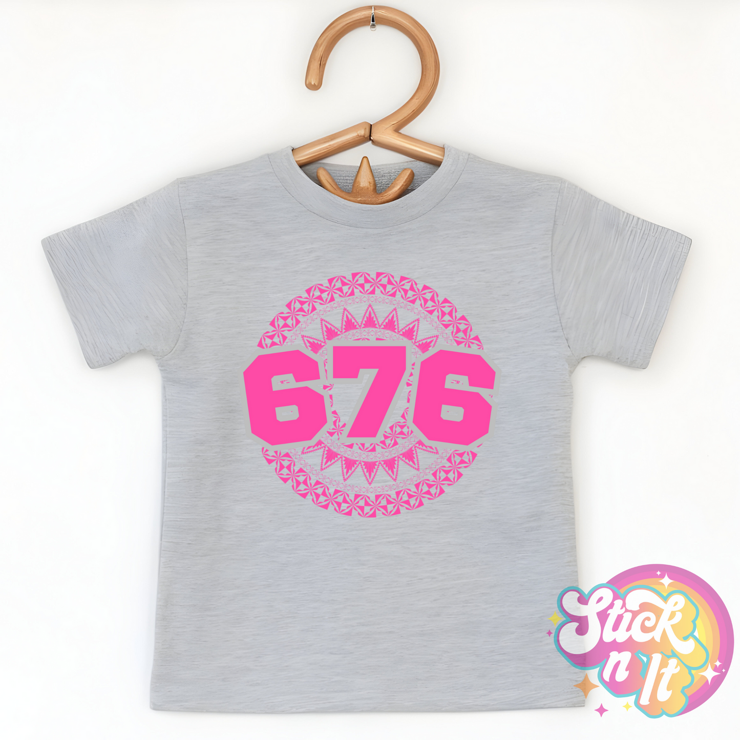 Kids size grey shirt featuring a Polynesian Tonga design with area code 676 in pink.