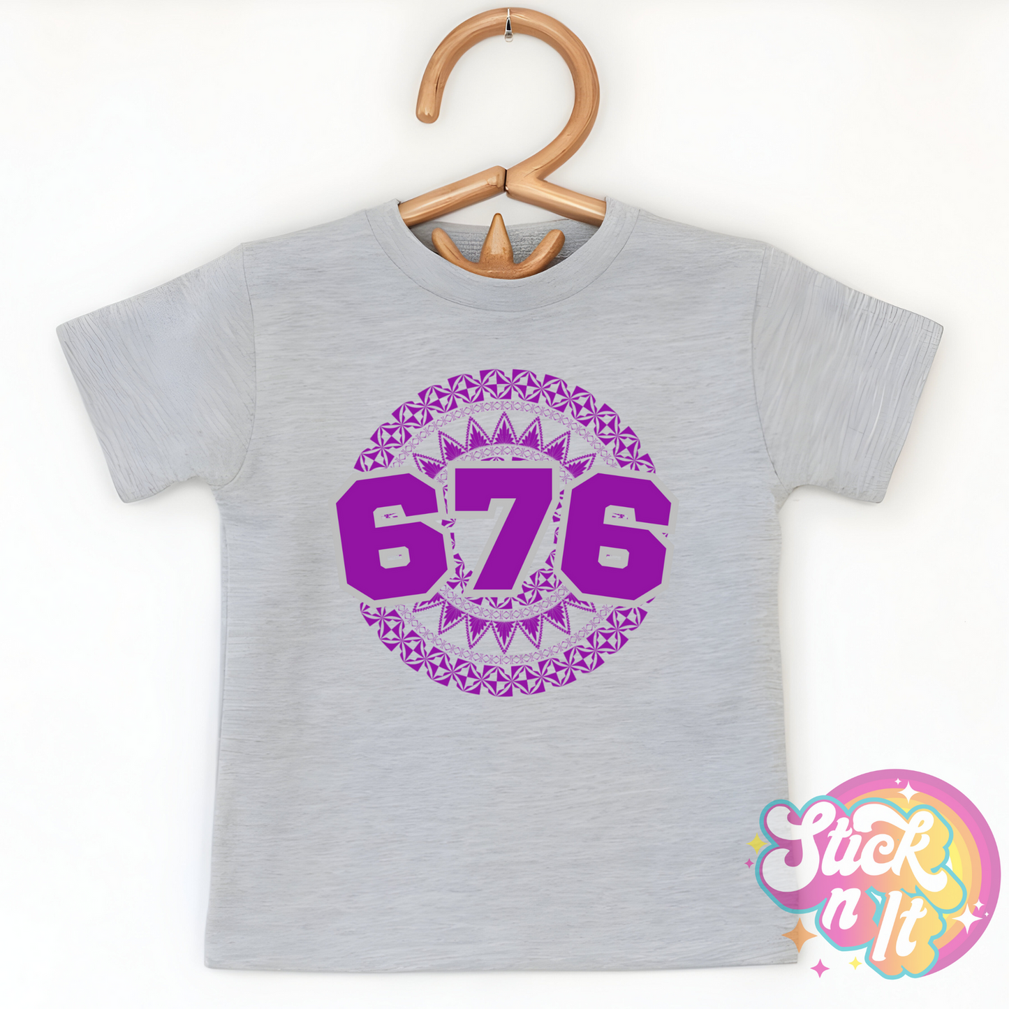 Kids size grey shirt featuring a Polynesian Tonga design with area code 676 in purple.