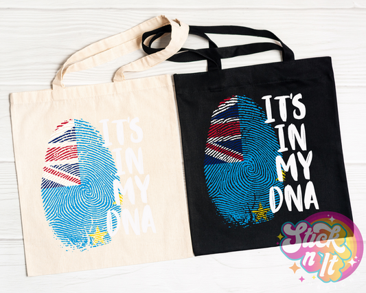 Black and natural colour tote bags featuring quote It's in my DNA in white with a fingerprint shaped Tuvalu flag